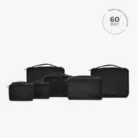 A set of beige packing cubes of various sizes with a white cube labeled '60 DAY'.