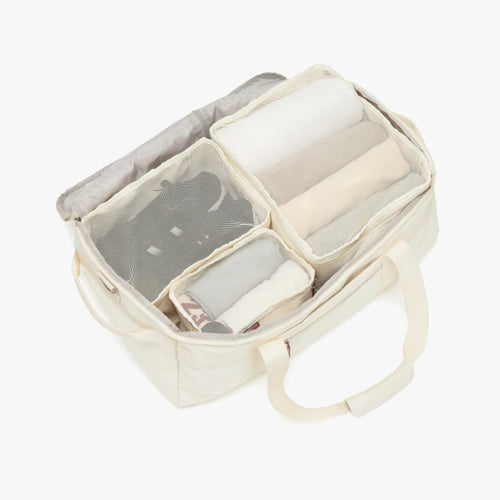 Organizer bag with compartments containing folded clothes on a white background